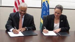 Nathan Younge, da USTDA, e Roberta Marchesi, da ANPTrilhos, assinam o acordo de cooperação na Embaixada dos Estados Unidos